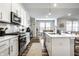 Open kitchen and dining area with modern appliances and beautiful lighting at 19009 Beverly Shones Ln, Noblesville, IN 46062