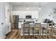 Bright kitchen features white cabinets, stainless steel appliances, and a modern island with seating at 19009 Beverly Shones Ln, Noblesville, IN 46062