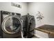 Modern laundry room with dark, front-load washer and dryer, plus a wooden folding counter at 19009 Beverly Shones Ln, Noblesville, IN 46062