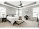 Bright main bedroom with tray ceiling, a ceiling fan, and large windows for natural light at 19009 Beverly Shones Ln, Noblesville, IN 46062