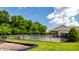 Community pool area featuring a black fence, shaded pavilion, and lush green trees under a blue sky at 19009 Beverly Shones Ln, Noblesville, IN 46062