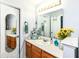 Bright bathroom vanity with wood cabinets, a large mirror, and decorative accessories for a warm and inviting feel at 20845 Summit Rd, Noblesville, IN 46062