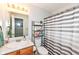 Cozy bathroom with a tub and shower, a white and gray striped shower curtain, and ample storage space at 20845 Summit Rd, Noblesville, IN 46062