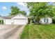 Charming single-story home boasts a two-car garage and beautifully landscaped front yard and great curb appeal at 20845 Summit Rd, Noblesville, IN 46062