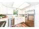 Bright kitchen features white cabinets, stainless steel appliances, and wood grain floors at 20845 Summit Rd, Noblesville, IN 46062