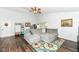 Cozy living room features wood floors, neutral paint, gray couch, a ceiling fan, and lots of natural light at 20845 Summit Rd, Noblesville, IN 46062