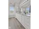 Bright bathroom featuring double sinks with granite countertops, white cabinets, and wood-look tile floors at 2096 Whitetail Ct, Avon, IN 46123