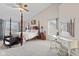 Spacious bedroom with a four-poster bed, carpet flooring, and a vanity desk at 2096 Whitetail Ct, Avon, IN 46123
