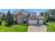 Charming two-story brick home with a well-manicured lawn and a spacious three-car garage at 2096 Whitetail Ct, Avon, IN 46123