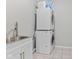 Laundry room featuring stacked washer and dryer, stainless steel sink, white cabinets and tile floor at 2096 Whitetail Ct, Avon, IN 46123