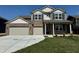 Charming two-story home featuring a brick facade, a spacious two-car garage, and a well-maintained lawn at 210 Ames Dr, Whiteland, IN 46184