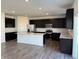 Modern kitchen boasts sleek dark cabinets, stainless steel appliances, and a large island with a white countertop at 210 Ames Dr, Whiteland, IN 46184