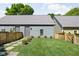 View of the detached garage with a fenced yard, stone path, and manicured bushes at 2140 Alabama St, Indianapolis, IN 46202