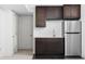 Close up of basement kitchenette with dark cabinets, stainless steel refrigerator, and sink area at 2140 Alabama St, Indianapolis, IN 46202