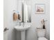 Stylish powder room with pedestal sink, decorative mirror, and neutral decor at 2140 Alabama St, Indianapolis, IN 46202