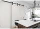 Modern kitchen featuring an island with seating, pendant lighting and a stylish sliding barn door at 2140 Alabama St, Indianapolis, IN 46202