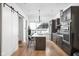 Modern kitchen featuring stainless steel appliances, island with seating and stylish sliding barn door at 2140 Alabama St, Indianapolis, IN 46202