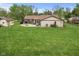 Spacious backyard featuring a patio with fire pit, outdoor seating, and mature trees perfect for outdoor living at 2303 Alexandria Dr, Greenfield, IN 46140