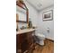 Bathroom featuring wood floors, a marble countertop vanity, and a framed silhouette wall art at 2303 Alexandria Dr, Greenfield, IN 46140