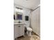 Modern bathroom with white vanity, tiled shower, decorative printed shower curtain and wood floors at 2303 Alexandria Dr, Greenfield, IN 46140