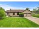 Charming ranch home with stone accents, attached two-car garage, and a well-manicured lawn at 2303 Alexandria Dr, Greenfield, IN 46140