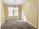 Cozy dining area with neutral walls, plush carpeting, and an elegant chandelier for ambient lighting at 2444 Cole Branch Ct, Indianapolis, IN 46239