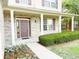 Inviting front porch with white columns, brick accents, and a well-manicured garden with colorful flowers at 2444 Cole Branch Ct, Indianapolis, IN 46239