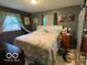 Cozy bedroom featuring a queen-size bed with colorful bedding, complemented by natural light from the windows at 2650 Woodrow Ave, Indianapolis, IN 46241