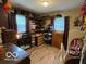 Bedroom with open shelving displaying clothing and shoes, and natural light from two windows at 2650 Woodrow Ave, Indianapolis, IN 46241
