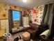 Floral bedroom featuring an upholstered ottoman, leather chair, and a window with floral detail at 2650 Woodrow Ave, Indianapolis, IN 46241