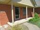 Cozy covered front porch with brick columns, a glass front door, and manicured shrubbery at 2996 Colony Lake W Dr, Plainfield, IN 46168