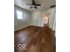 Spacious living room featuring hardwood floors and a ceiling fan with a kitchen view at 3026 S Rybolt Ave, Indianapolis, IN 46241