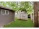 Backyard shed and lush green grass with a wooden fence at 3149 Thayer St, Indianapolis, IN 46222
