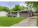 Quaint single-story home featuring a lush front lawn and adjacent driveway at 3149 Thayer St, Indianapolis, IN 46222