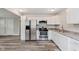 Well-lit kitchen featuring stainless steel appliances, white cabinets, and hardwood floors at 3149 Thayer St, Indianapolis, IN 46222