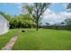 Large, well-maintained backyard featuring a lush lawn, mature trees, and a fire pit area at 3538 N Elizabeth St, Indianapolis, IN 46226