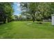 Wide shot of a large backyard, with a lush green lawn, mature trees, and a fenced perimeter at 3538 N Elizabeth St, Indianapolis, IN 46226