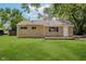 Charming single-story home showcasing a stone facade, green lawn, and mature trees at 3538 N Elizabeth St, Indianapolis, IN 46226