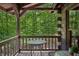 Cozy back porch featuring seating, offering a tranquil outdoor space with views of the surrounding woodland at 3715 Orchard Rd, Columbus, IN 47201