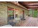 Inviting covered back porch with outdoor seating, featuring a grill and view of the wooded surroundings at 3715 Orchard Rd, Columbus, IN 47201