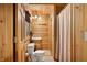 Rustic bathroom with wood paneling, a classic toilet, vanity, and shower with curtain at 3715 Orchard Rd, Columbus, IN 47201