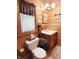 Charming bathroom featuring wood accents, a toilet, and sink with a window view at 3715 Orchard Rd, Columbus, IN 47201