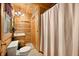 Well-lit bathroom featuring a sink, shower, and toilet with natural wood accents at 3715 Orchard Rd, Columbus, IN 47201