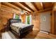 Cozy bedroom featuring wood walls, a queen-sized bed, and a decorative wall art piece at 3715 Orchard Rd, Columbus, IN 47201