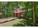 A cozy log cabin nestled in the trees with a red metal roof and wooden walkway at 3715 Orchard Rd, Columbus, IN 47201