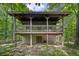 Rustic cabin featuring a covered porch and a block foundation, surrounded by lush greenery at 3715 Orchard Rd, Columbus, IN 47201