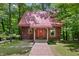 Inviting log cabin with red roof, decorative flower boxes and a charming wooden walkway at 3715 Orchard Rd, Columbus, IN 47201