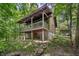 Charming log cabin with a covered porch, set amidst a verdant, wooded landscape at 3715 Orchard Rd, Columbus, IN 47201