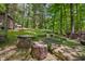 Outdoor fire pit area with natural log seating, set amongst the trees for cozy evenings under the stars at 3715 Orchard Rd, Columbus, IN 47201