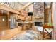 Cozy wooden cabin interior featuring a stone fireplace, kitchen, and loft with natural lighting at 3715 Orchard Rd, Columbus, IN 47201